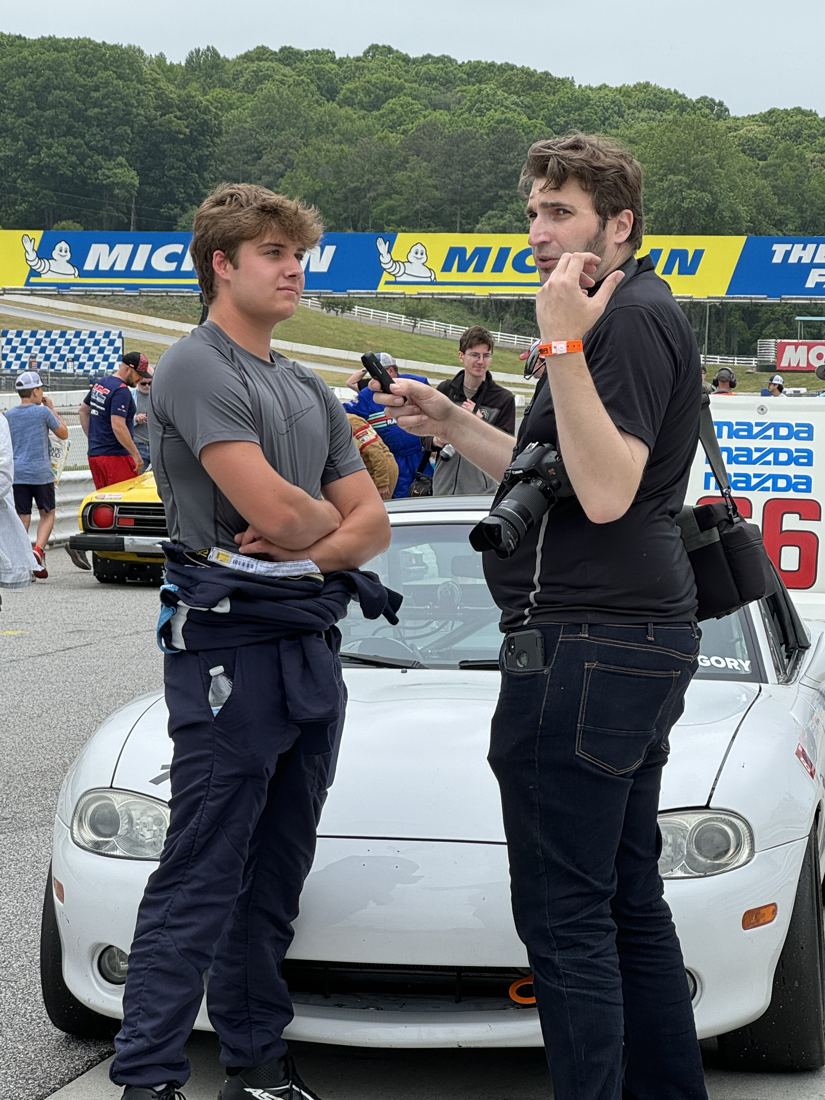 Carsten talking with a photographer on the grid at Road Atlanta