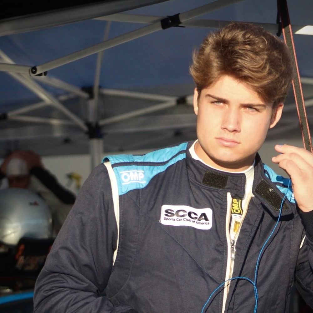 Carsten in race suit under a paddock tent