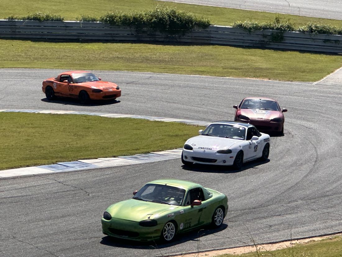 White #18 Spec Miata racing in a pack